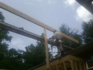 Carpenter setting a ridge beam over a new addition frame — Ice Dam Removal by Roofing Brothers in Mosinee
