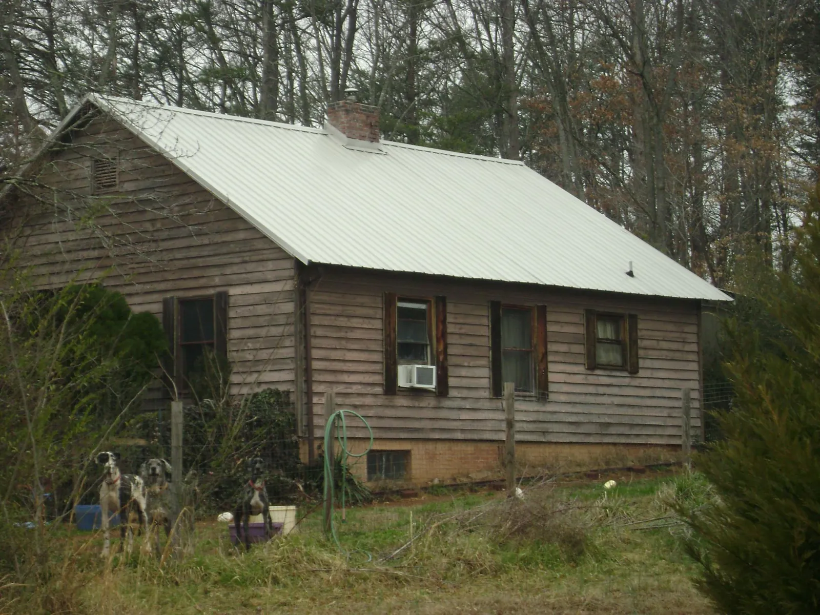 White metal roof on an old wood sided farmhouse, from a Metal Roof Installation job in Mosinee